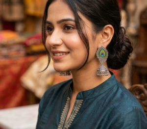 "This is a pair of oxidised silver peacock feather jhumka earrings"
